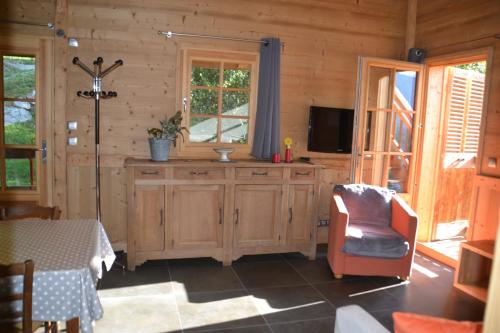 a living room with a tv and a chair at Chalet des fleurs in Samoëns