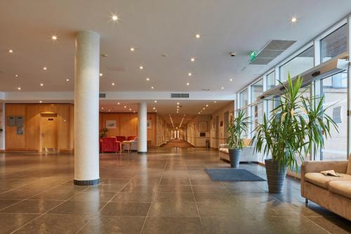 un hall avec piliers et plantes dans un bâtiment dans l'établissement Future Inn Plymouth, à Plymouth