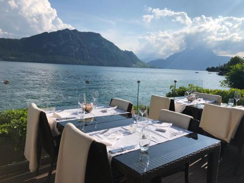 a table with wine glasses on it next to a lake at Post Hotel Weggis in Weggis
