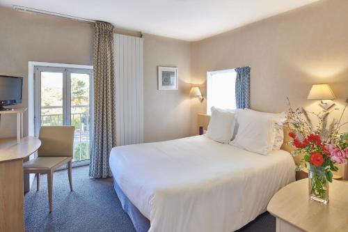 Ένα ή περισσότερα κρεβάτια σε δωμάτιο στο Hôtel Vacances Bleues Villa Caroline
