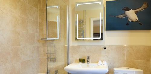 een badkamer met een douche, een wastafel en een spiegel bij Humble Bee Farm in Scarborough