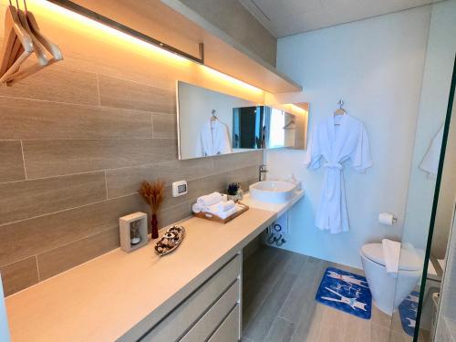 a bathroom with a sink and a toilet and a mirror at Veranda Residence Pattaya x Sea & Sky View in Na Jomtien