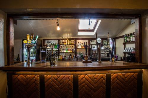 a bar in a pub with a wooden counter at Marston Farm Hotel in Sutton Coldfield