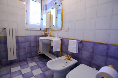 a blue and white bathroom with a sink and a toilet at Eremo delle Grazie in Ispica
