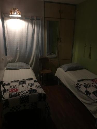 a bedroom with two beds and a window and a lamp at The Little Blue Window Hostel in Bengaluru
