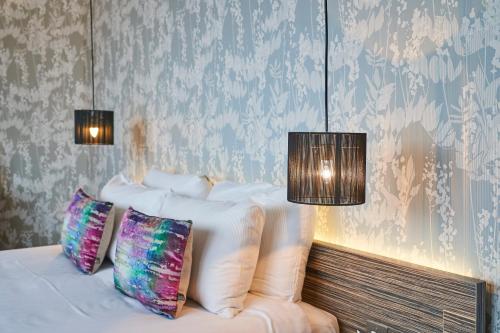 a bedroom with a white bed with two pillows at Hotel Bosco in Kingston upon Thames