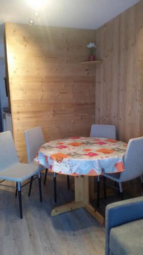 レ・デュー・アルプにあるStudio COTE BRUNE 2 ALPESの木製の壁の客室で、テーブルと椅子が備わります。