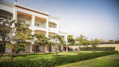 a large white building with trees in front of it at ROBINSON AGADIR - All Inclusive in Agadir