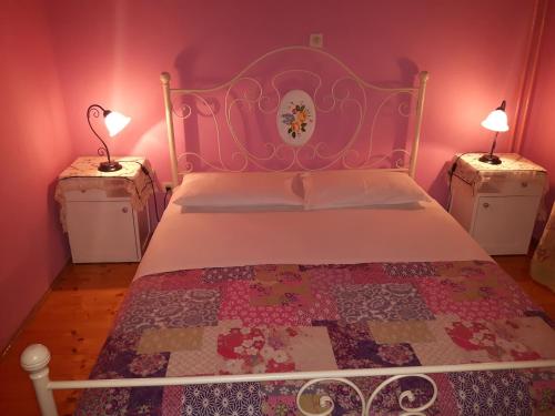 a bedroom with a bed and two night stands with lamps at NOOR Apartment and Room in Hvar