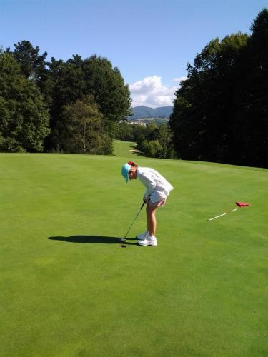 a woman is playing golf on a field at Caserta in Hondarribia