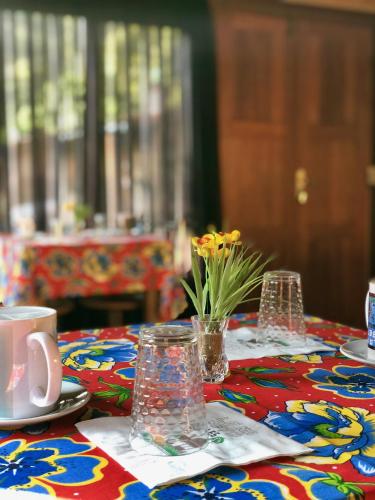a table with a colorful table cloth with flowers on it at Pousada Chalés Jardim das Bromélias - Visconde de Mauá in Visconde De Maua