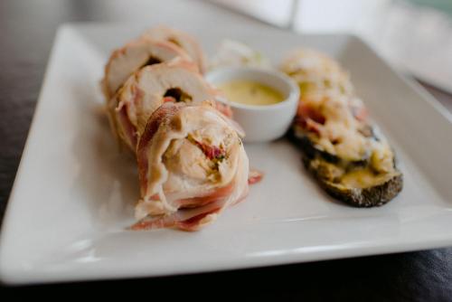 a plate of food with a sandwich and dipping sauce at La Campiña Club Hotel & Spa in Santa Rosa