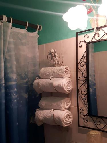a stack of towels in a bathroom next to a mirror at NOOR Apartment and Room in Hvar