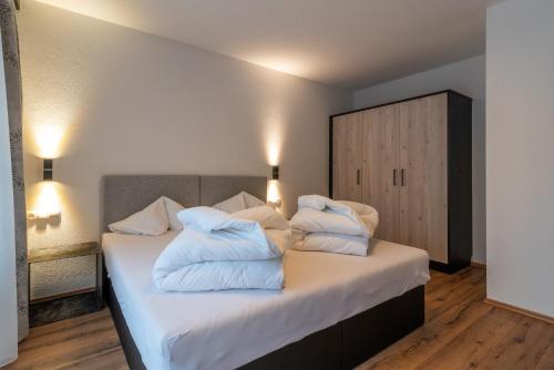 a bedroom with a bed with white pillows on it at A CASA Rubin Chalet & Studio Resort in Sölden