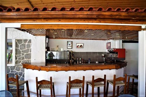 a bar in a restaurant with chairs and a counter at Attica Hotel Ephie in Souvala