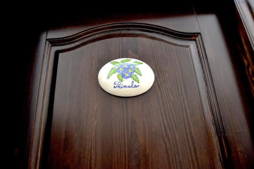a sign on a door with a flower on it at Ostello Salento in Alezio