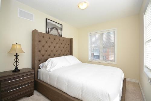 um quarto com uma cama, uma cómoda e uma janela em Townhome Collection By Royal Stays - Milton ON em Milton
