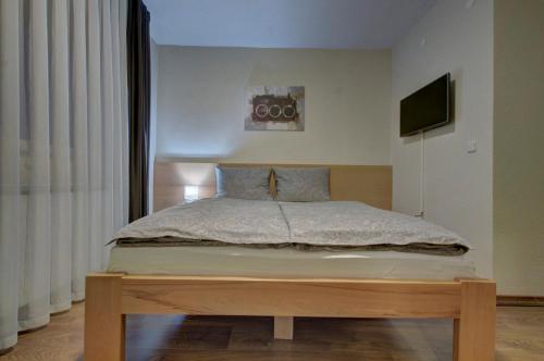 a bedroom with a large bed with a wooden platform at Tihe Noci Motel in Pale