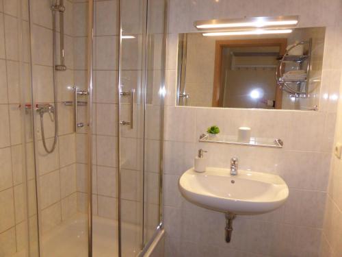 ein Bad mit einer Dusche, einem Waschbecken und einer Dusche in der Unterkunft Pension Nord in Dessau
