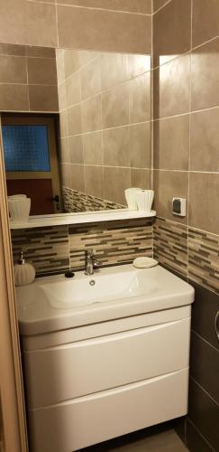 uma casa de banho com um lavatório branco e um espelho. em Hôtel Sable d'Or em Tan-Tan