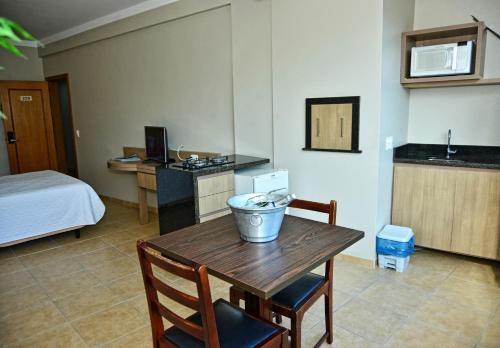 a room with a kitchen and a table and a bed at De Rose Praia Hotel in Torres