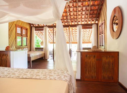 a bedroom with a bed with a canopy at La Ferme De Georges in Atins