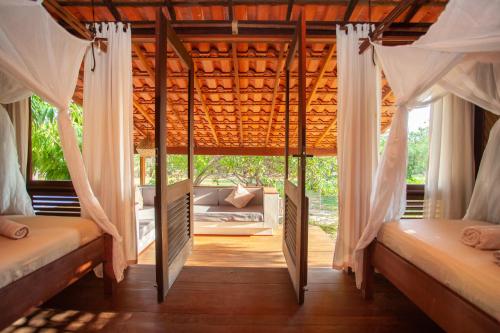 two beds in a room with windows at La Ferme De Georges in Atins