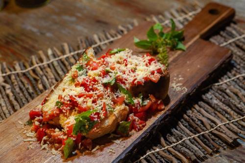 a slice of pizza on a wooden cutting board at La Ferme De Georges in Atins