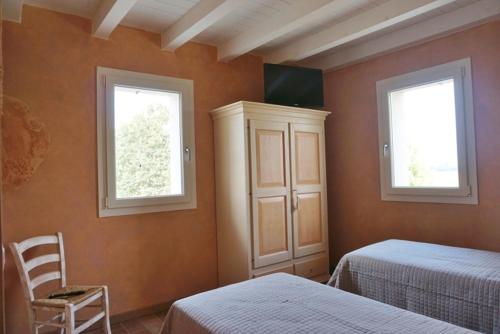 a bedroom with two beds and two windows at agriturismo campogrande in Carpaneto Piacentino