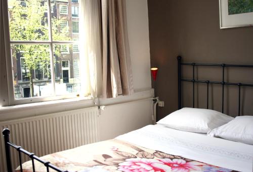 a bedroom with a bed next to a window at Hostel The Veteran in Amsterdam