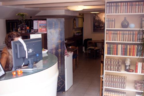 a woman sitting at a counter in a book store at Hostel The Veteran in Amsterdam