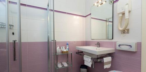 a bathroom with a sink and a glass shower at Hotel Lis in Asti