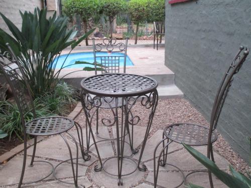 a table and four chairs sitting next to a pool at Flamboyant Guesthouse in Bela-Bela