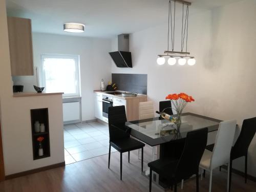 cocina y comedor con mesa y sillas en Ferienwohnung am Reinhardswald - Eichenlaub - mit Sauna, en Trendelburg