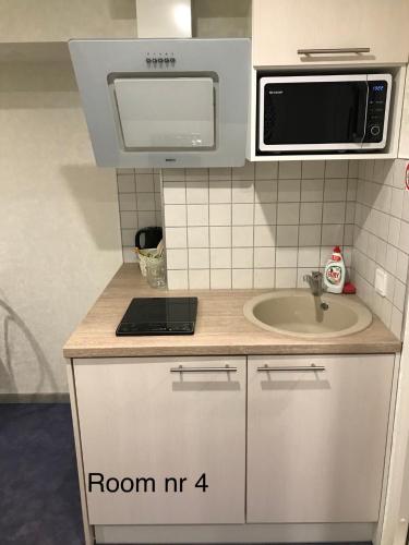 a small kitchen with a sink and a microwave at Liivalaia 40 cozy kitchen studio in Tallinn