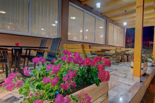 a room with pink flowers and a table and chairs at Tihe Noci Motel in Pale