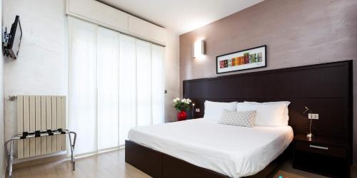 a bedroom with a large bed and a large window at Hotel Lis in Asti