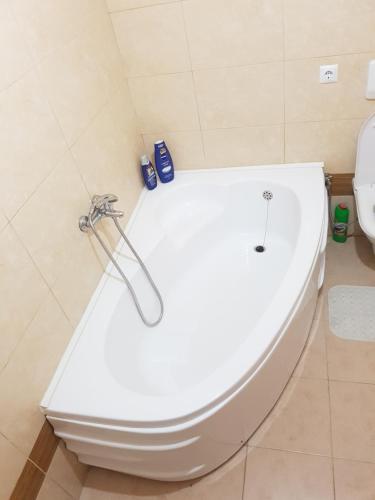 een badkamer met een wit bad en een toilet bij Tetovo Apartment Superb Location in Tetovo