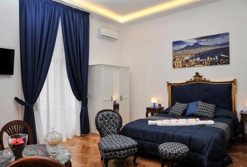 Schlafzimmer mit blauem Bett und blauen Vorhängen in der Unterkunft Di Palma Suite in Neapel