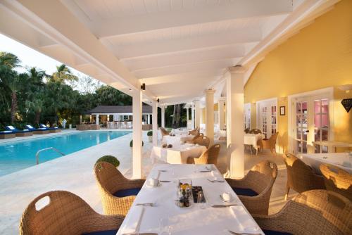 a restaurant with a pool and tables and chairs at Tortuga Bay in Punta Cana