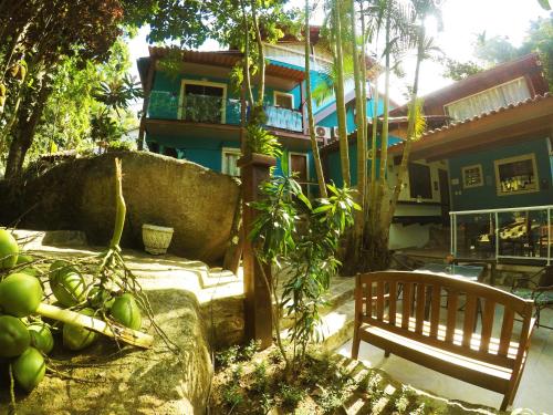 a bench sitting in front of a building with fruit at Pousada Guapuruvu in Abraão