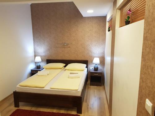 a bedroom with a bed with two yellow pillows at B&B Bazeni in Sarajevo
