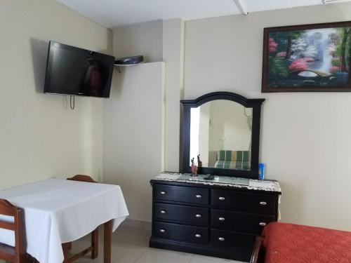 a bathroom with a dresser with a mirror and a table at Casa Serena in Guayaquil