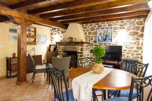 uma sala de jantar com uma mesa e uma lareira de pedra em Casa El Campano em Ontaneda