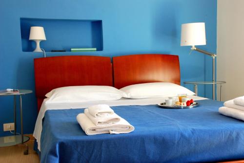 a blue bedroom with a bed with towels on it at B&B Dunedorate in Punta Secca