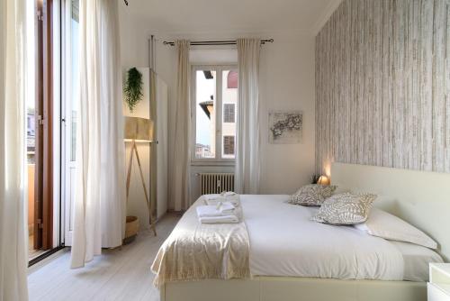 ein Schlafzimmer mit einem weißen Bett und einem Fenster in der Unterkunft White Napoleone Apartment in Rom