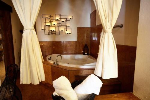a bathroom with a tub and a chandelier at Hotel Quinta Mision in Creel