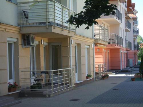 a building with a balcony on the side of it at Aqua Wellness Apartments in Hajdúszoboszló