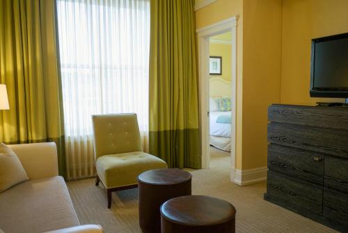 a living room filled with furniture and a tv at Hotel DeLuxe, a Provenance Hotel in Portland