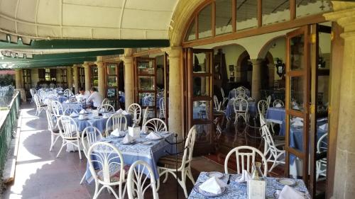 a restaurant with blue tables and white chairs at Gran Hotel Hacienda De La Noria in Aguascalientes